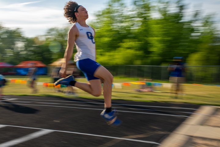 A runner captured against a blurred trackside background.